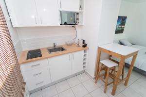 a small kitchen with a sink and a table at BOULEVARD LEGITIMUS in Pointe-à-Pitre
