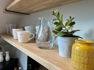 a shelf with a vase and a plant on it at Pear Tree Loft in Lacock