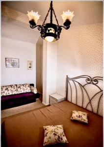 - un salon avec un lit et un lustre dans l'établissement Casa Beatrice, à Grăjdana