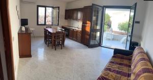 sala de estar y cocina con mesa y sillas en Bilo Lu Rattali, en San Teodoro