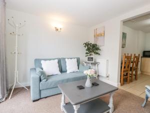 a living room with a blue couch and a table at Thornhills Cottage in Bridgwater