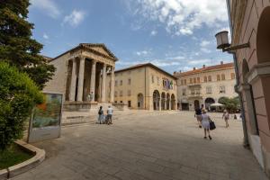 a group of people walking in a plaza at Apartment Augusto - Sea view in Pula