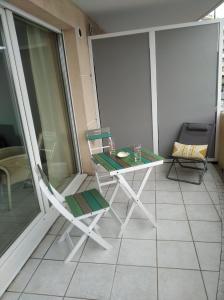 uma varanda com uma mesa e uma cadeira num edifício em Sainte Rosalie em Cannes