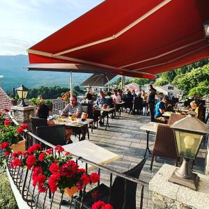 a group of people sitting at tables on a patio at Hotel La Terrasse in Zonza