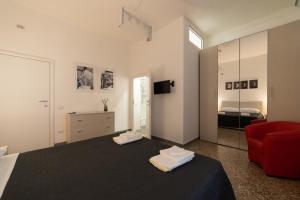 1 dormitorio con 1 cama y 1 silla roja en La Casa Sul Melo, en Matera