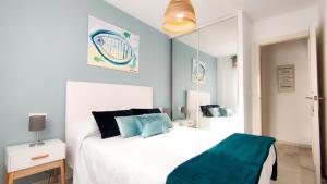 a bedroom with a white bed and a mirror at Laguna Beach Paradise - Alojamientos La Torre in Torrox Costa