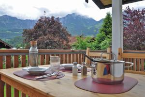 a wooden table with a pot and plates on a balcony at Ferienwohnung Zulehenweg 15 in Schönau am Königssee +2 photos