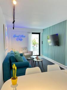 a living room with a blue couch and a table at Becool Apartment in Porto Rafti