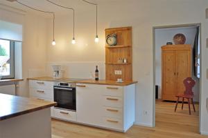 舍瑙阿姆克尼格塞的住宿－Ferienwohnung Zulehenweg 15，厨房配有白色橱柜和台面