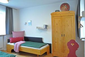 a small room with a bed and a wooden cabinet at Ferienwohnung Zulehenweg 15 in Schönau am Königssee