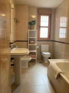 een badkamer met een wastafel, een toilet en een bad bij La casita de luis in Granada