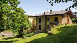a small yellow house with a grassy yard at Villa Natale in Sestola