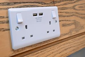 an electrical outlet on a wooden table at Swan, Thatcham by Marston's Inns in Thatcham