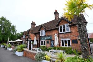 a brick building with umbrellas in front of it at Swan, Thatcham by Marston's Inns in Thatcham