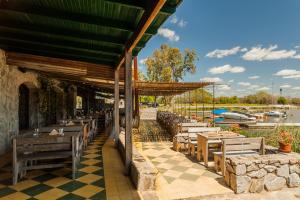 un restaurante con mesas de madera en un suelo a cuadros en Suites Camacho, en Carmelo