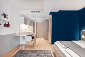 a bedroom with a bed and a blue accent wall at Vonder Munich in Munich