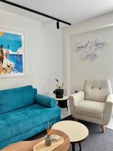 a living room with a blue couch and a chair at Becool Apartment in Porto Rafti