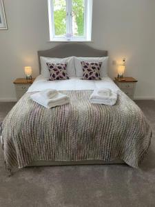 a bedroom with a large bed with towels on it at 29 Malthouse Alnwick Holiday Apartment in Alnwick