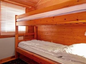 ein Etagenbett in einem Holzzimmer mit einem Bett in einem Zimmer in der Unterkunft Holiday Home Lomasyväri 810 by Interhome in Nilsiä + 7 Fotos
