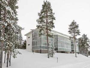 un edificio en la nieve frente a los árboles en Holiday Home Golfstar 402 by Interhome, en Kiviniemi