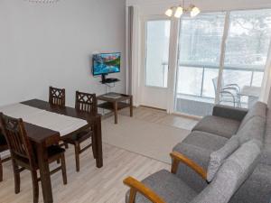 sala de estar con mesa, sofá y TV en Holiday Home Golfstar 402 by Interhome, en Kiviniemi