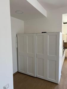 dwa białe drzwi garażowe w białym pokoju w obiekcie Bibi House w mieście Nocera Inferiore