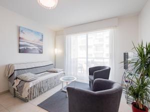 - un salon avec un lit et deux chaises dans l'établissement Apartment L'Hippocampe T2 balcon by Interhome, à Les Sables-dʼOlonne