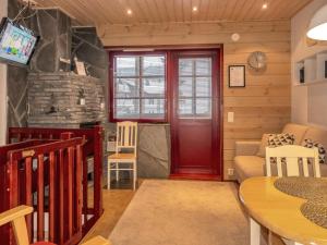 a living room with a red door and a couch at Holiday Home Levin otava 4 by Interhome in Sirkka