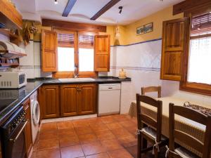uma cozinha com armários de madeira e um forno com placa de fogão em Holiday Home Rosa by Interhome em Cabanes