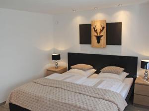 um quarto com uma cama grande com lençóis brancos e almofadas em Apartment Ehinger by Interhome em Eisenbach