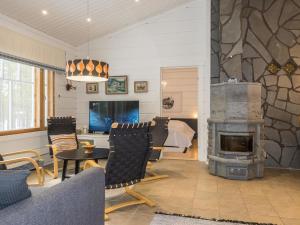 a living room with a fireplace and a table and chairs at Holiday Home Petsukantähti by Interhome in Sirkka