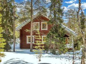 una baita di tronchi nel bosco nella neve di Holiday Home Villa hanhi by Interhome a Rovaniemi