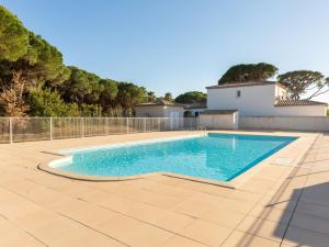 a swimming pool on a patio with a fence at Holiday Home Le Mas d'Esquières 16 by Interhome in Les Issambres