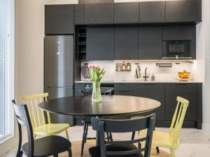 eine Küche mit einem Tisch und Stühlen sowie einem Kühlschrank in der Unterkunft Holiday Home Villa kuortane by Interhome in Kuortane