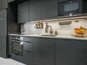 a kitchen with black cabinets and a sink at Holiday Home Villa kuortane by Interhome in Kuortane