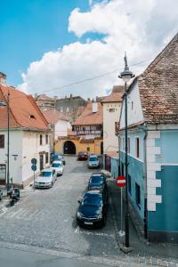 een straat met auto's geparkeerd in een klein stadje bij Casa Gallo in Sibiu