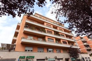 un alto edificio arancione con piante sui balconi di B&B Sol Romae a Roma