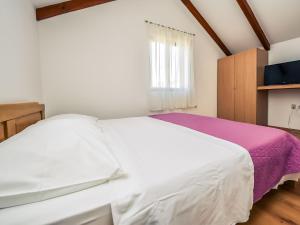 ein Schlafzimmer mit einem weißen Bett und einem Fenster in der Unterkunft Holiday Home Jolumar by Interhome in Biograd na Moru