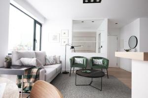 sala de estar con sofá y 2 sillas verdes en Agua Marina, en A Guarda