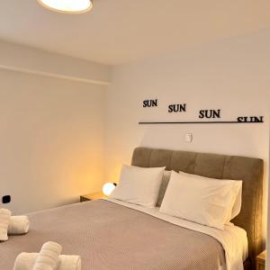a bedroom with a bed with two signs on the wall at Becool Apartment in Porto Rafti