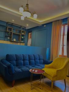 a blue couch and a chair in a living room at Promenade Hotel in Shkodër