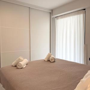 a bedroom with a bed with towels on it at Becool Apartment in Porto Rafti