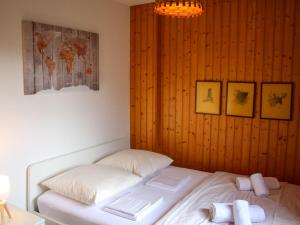 a bed in a room with a wooden wall at Chalet Chalet Les Pitchounes by Interhome in Moleson
