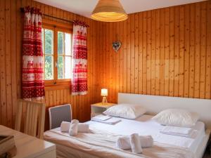sypialnia z 2 łóżkami i drewnianymi ścianami w obiekcie Chalet Chalet Les Pitchounes by Interhome w mieście Moleson