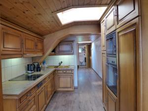 eine Küche mit Holzschränken und einem Dachfenster in der Unterkunft Apartment Brienz Sunset by Interhome in Brienz