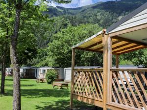 a wooden pavilion with a picnic table and mountains in the background at Holiday Home Draucamping-2 by Interhome in Sachsenburg