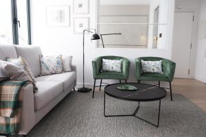 sala de estar con sofá y 2 sillas verdes en Agua Marina, en A Guarda