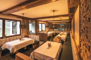 restauracja ze stołami z białą tkaniną w obiekcie Panoramahotel Schwendbergerhof w mieście Hippach