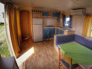 una cocina con armarios azules y una mesa verde en una caravana en Holiday Home Prima by Interhome en Praga