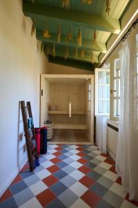 una camera con pavimento a scacchi e una grande finestra di Villa Marengo Guest House a Spinetta